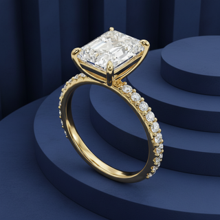 Gold ring with a large diamond and smaller diamonds on a blue background